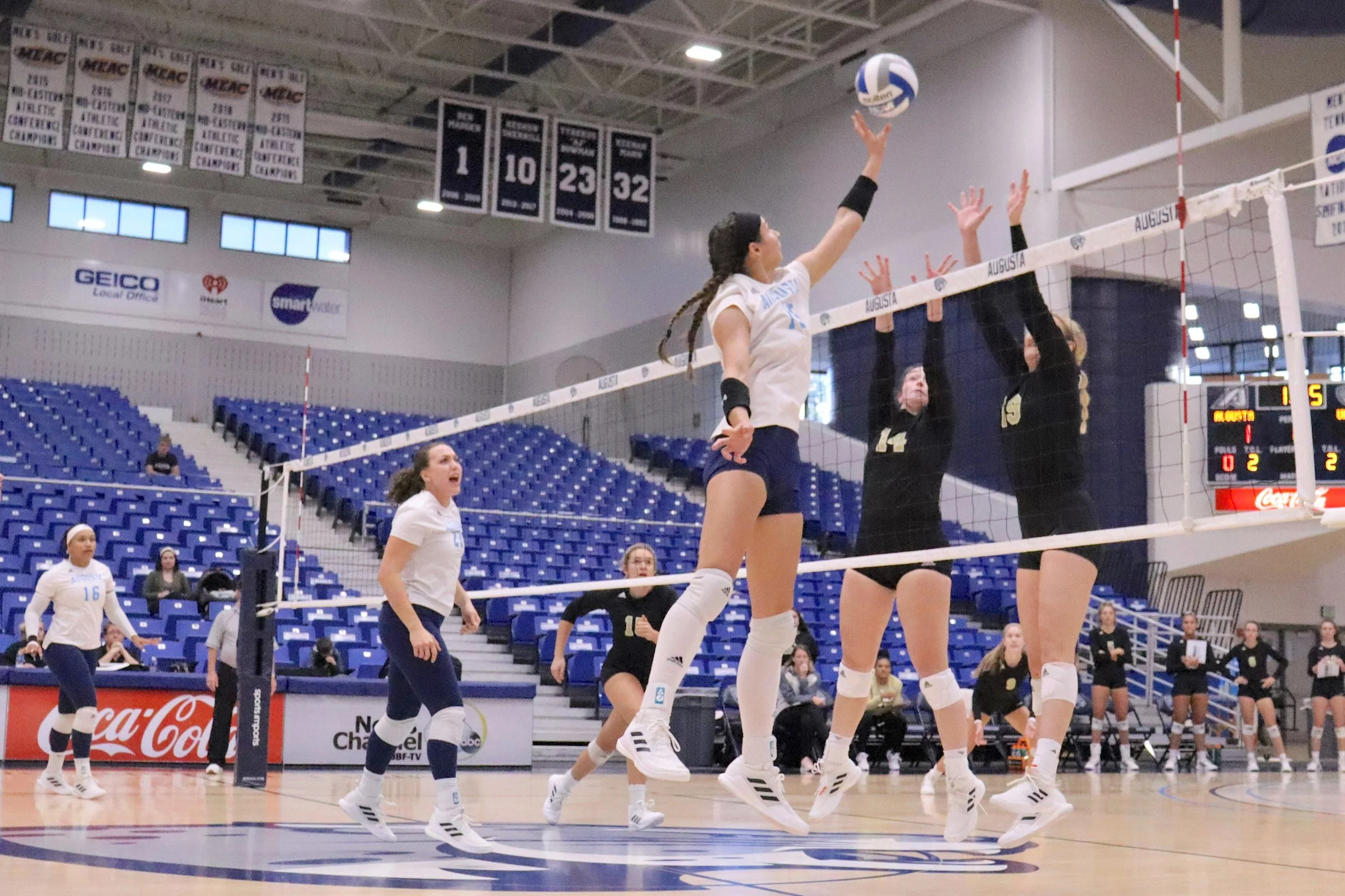  AU middle blocker Madelyn Eden (15) goes up for the touch kill while teammates Alexis Diaz-Infante (21) and Jazmyn Wheeler (16) watch. At the top of the page, Wheeler prepares to take a big swing on a night when she had 14 kills. (photos by Madison Keel) 