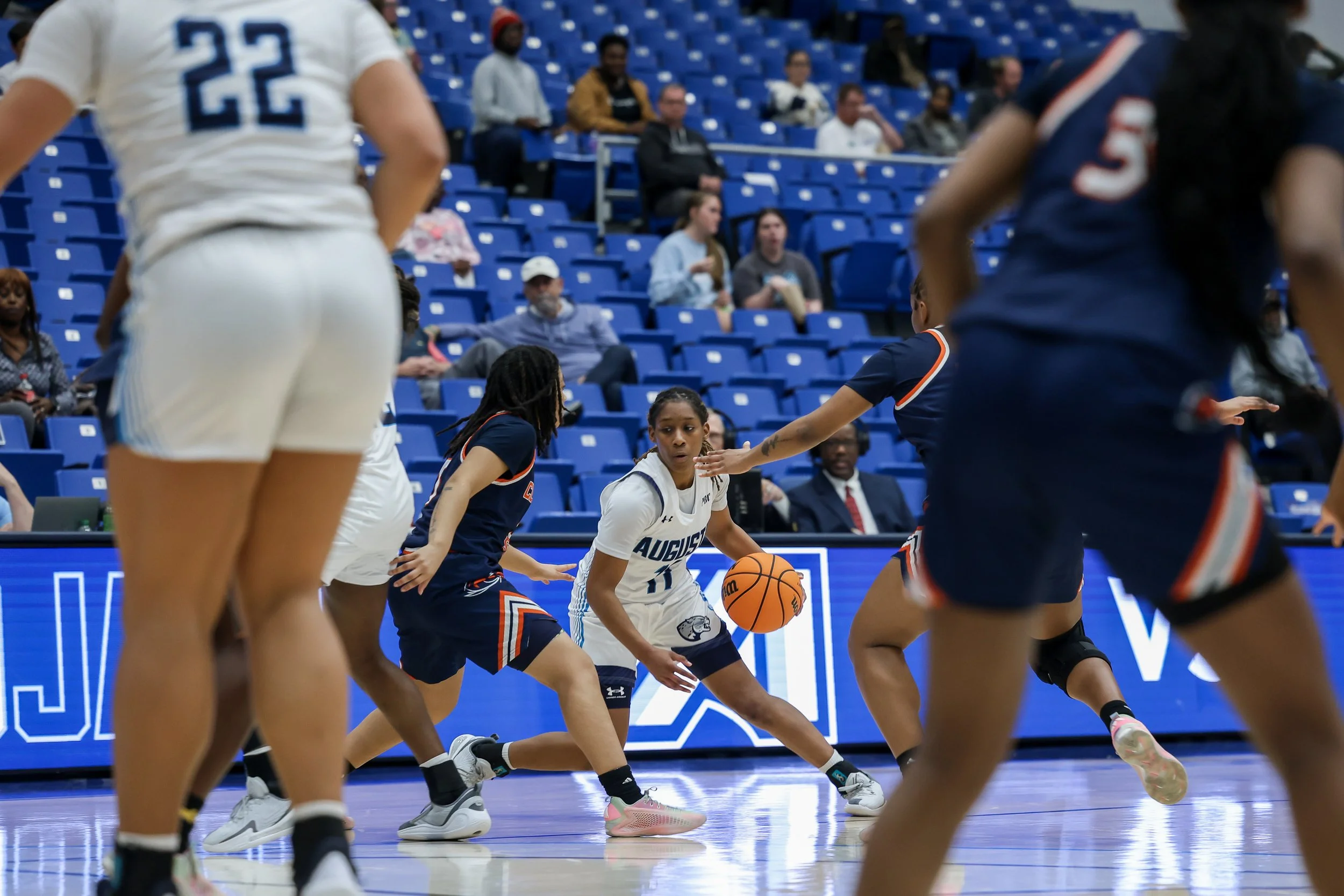  AU’s Sa’Niah Dorsey (11) attempts to dribble away from the incoming double-team. At the top of the page, Dorsey elevates over the defense to score a deuce. (photos by Lydia Williams/the Bell Ringer) 