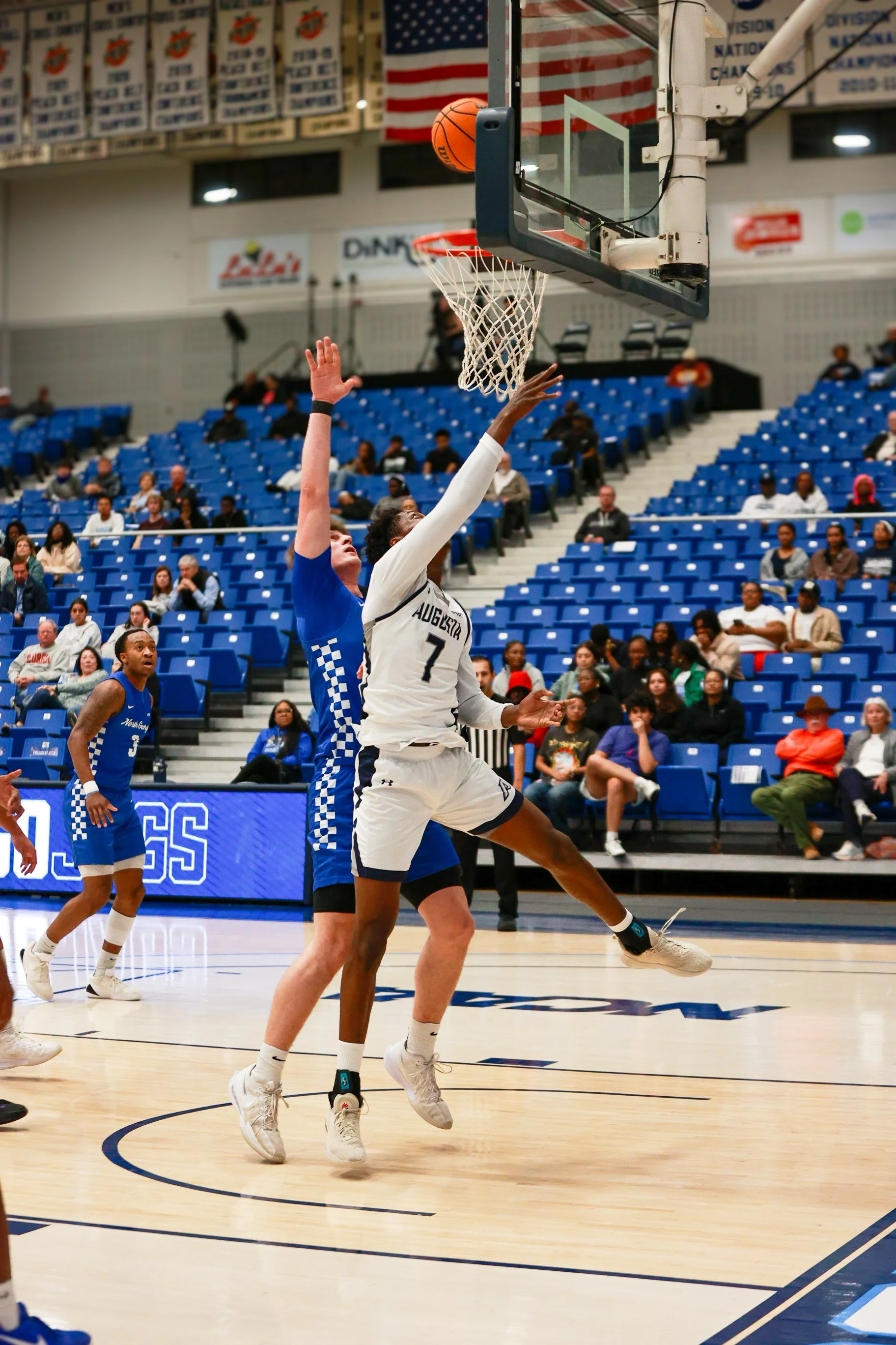  At the top of the page, AU’s Evan Joyner (0) drives to the basket for a layup. Joyner played his last ever game at Christenberry Fieldhouse while sporting the Jaguar colors. (photo by Lydia Williams/the Bell Ringer)   Below, Daniel Daramola goes reverse down the baseline for two. Daramola led the Jaguars with 14 points. (photo by Rodrigo Burgos Avila/the Bell Ringer) 