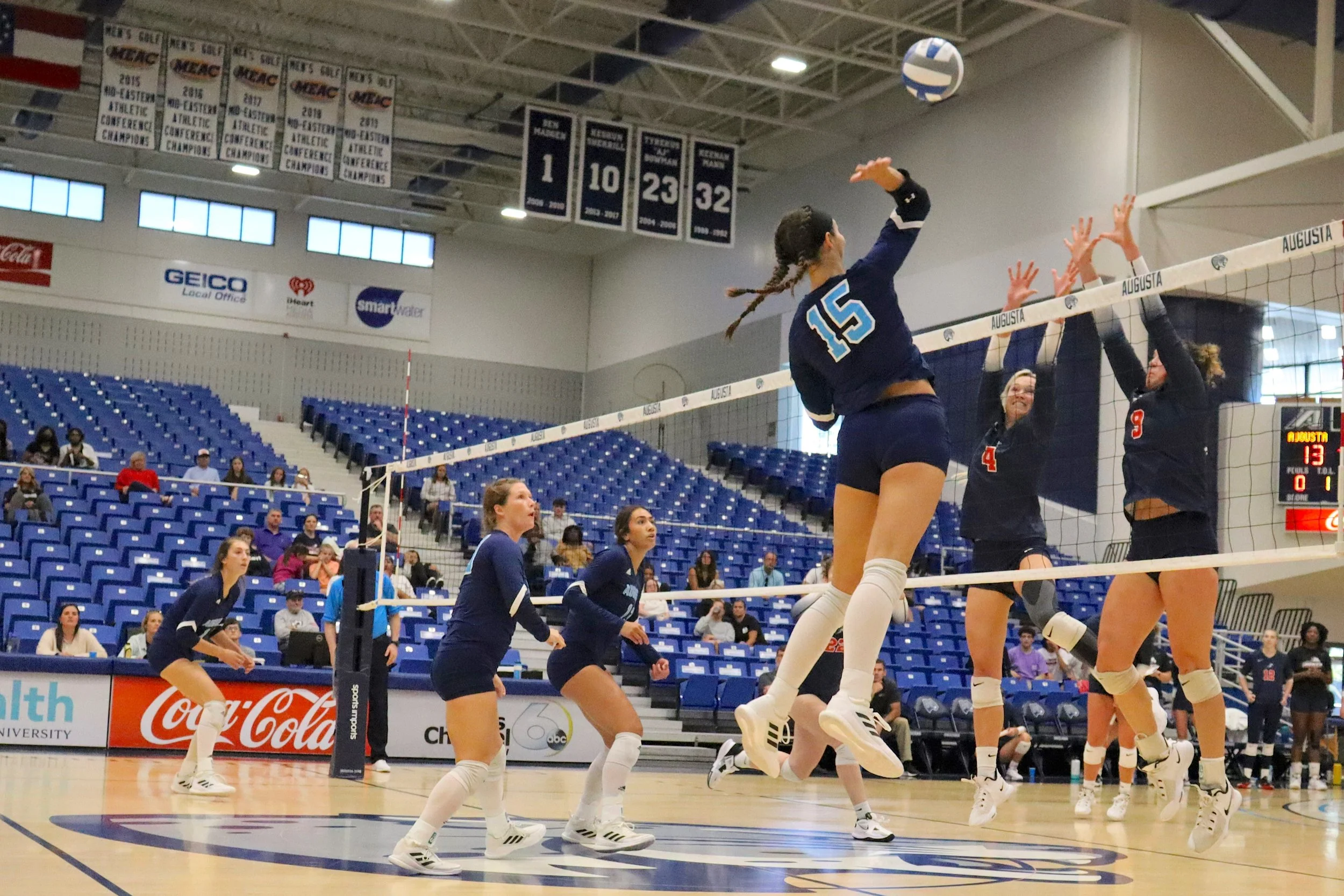  Augusta University outside hitter Madelyn Eden (15) gets the kill for AU in the five-set victory over the Pacers. At the top of the page, the Jaguars celebrate after winning over USC Aiken. From left to right: Dariana Luna (7), Coach Sharon Quarles, Kiera Barr, Jazmyn Wheeler (16), Samantha Zittrauer (10),  Jada Suguturaga and Madelyn Eden (15). (photos by Madison Keel) 