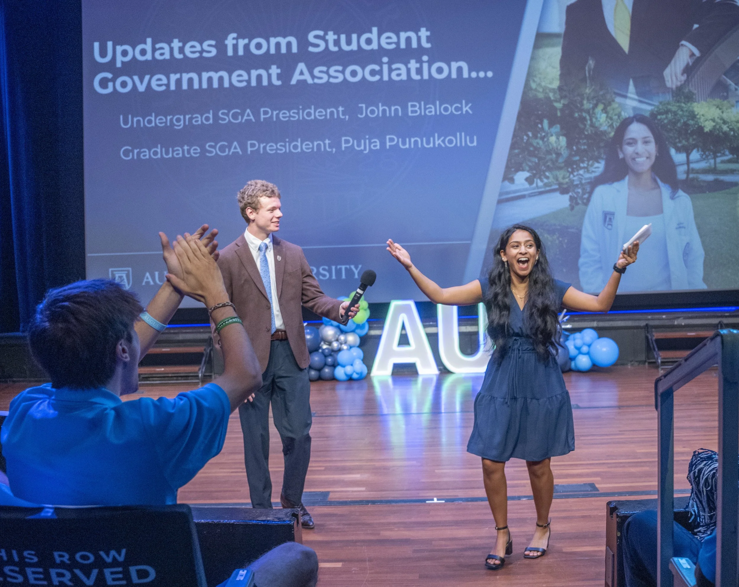  Graduate SGA President Puja Punukollu (R) greets those attending President Russell Keen’s Fall 2025 Kickoff. Holding the microphone is Undergraduate SGA President John Blalock. At the top of the page, Susan Davies, executive vice president for enrollment and student affairs, breaks down the record enrollment at AU as Fall 2025 classes begin on Aug. 11. (photos by Michael Holohan/DCM) 