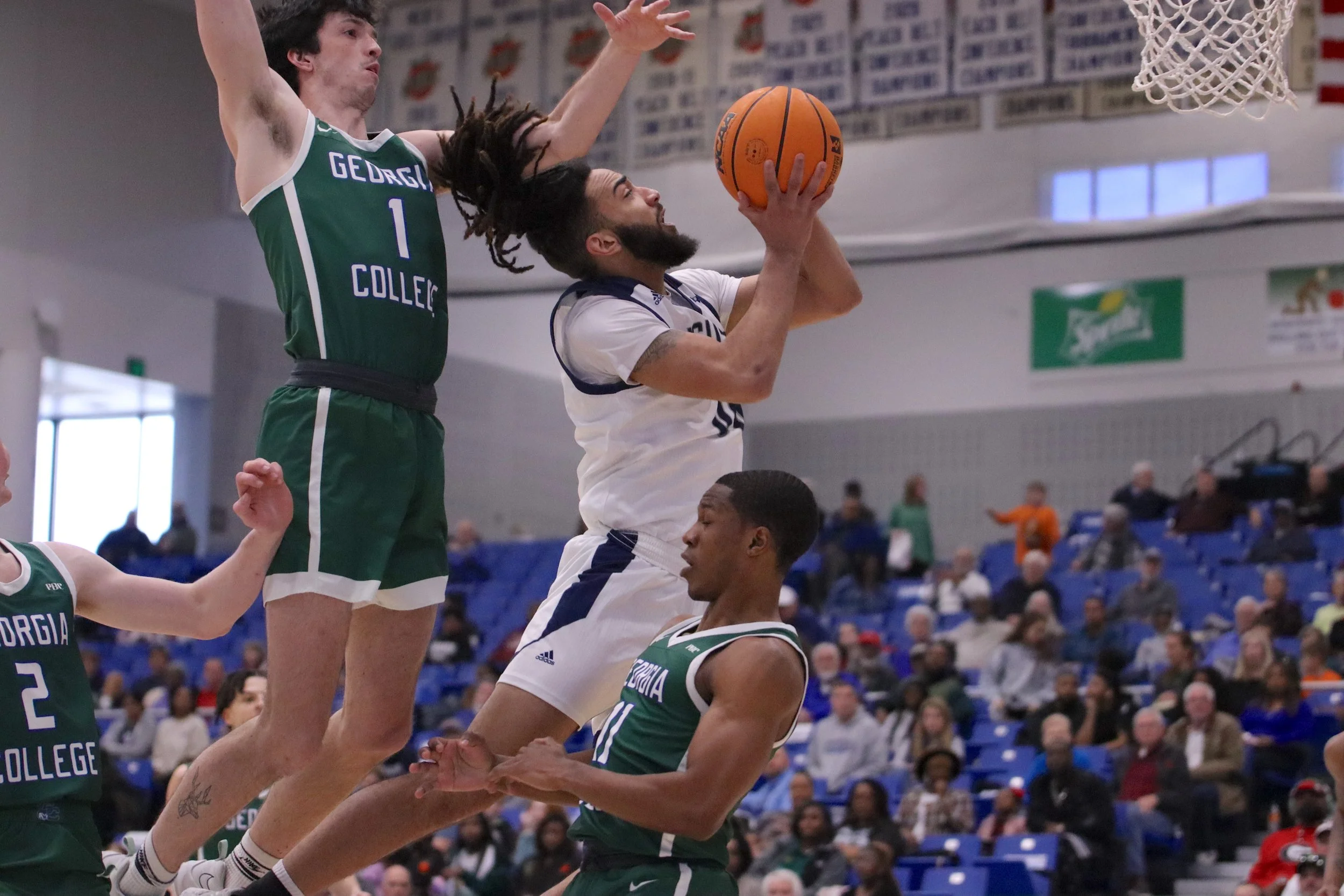 Demitri Gardner (C) goes up for two of his 10 points in the Jaguars’ 86-61 win over Georgia College. At the top of the page, Miguel Arnold (5) had 10 points and four steals for the Peach Belt Conference leaders. (photos by Madison Keel) 