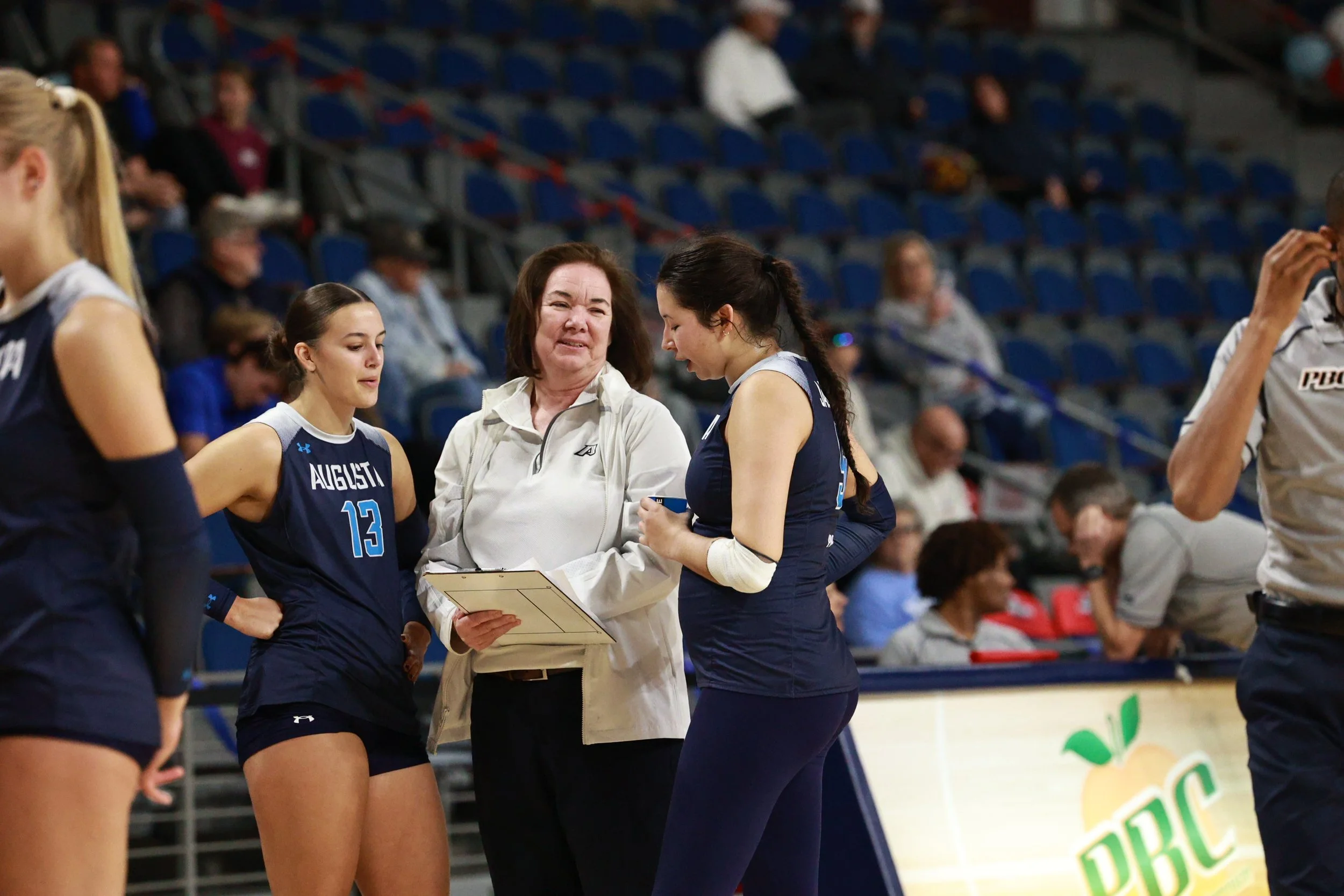  At the top of the page, Angela Mateos (13) swings on the outside, her first time playing the position this season.  Below, Coach Sharon Quarles discusses a play with Sydney Harrington (13) and Mia Saavedra (right) during a timeout. (photos by Rodrigo Burgos Avila/the Bell Ringer) 