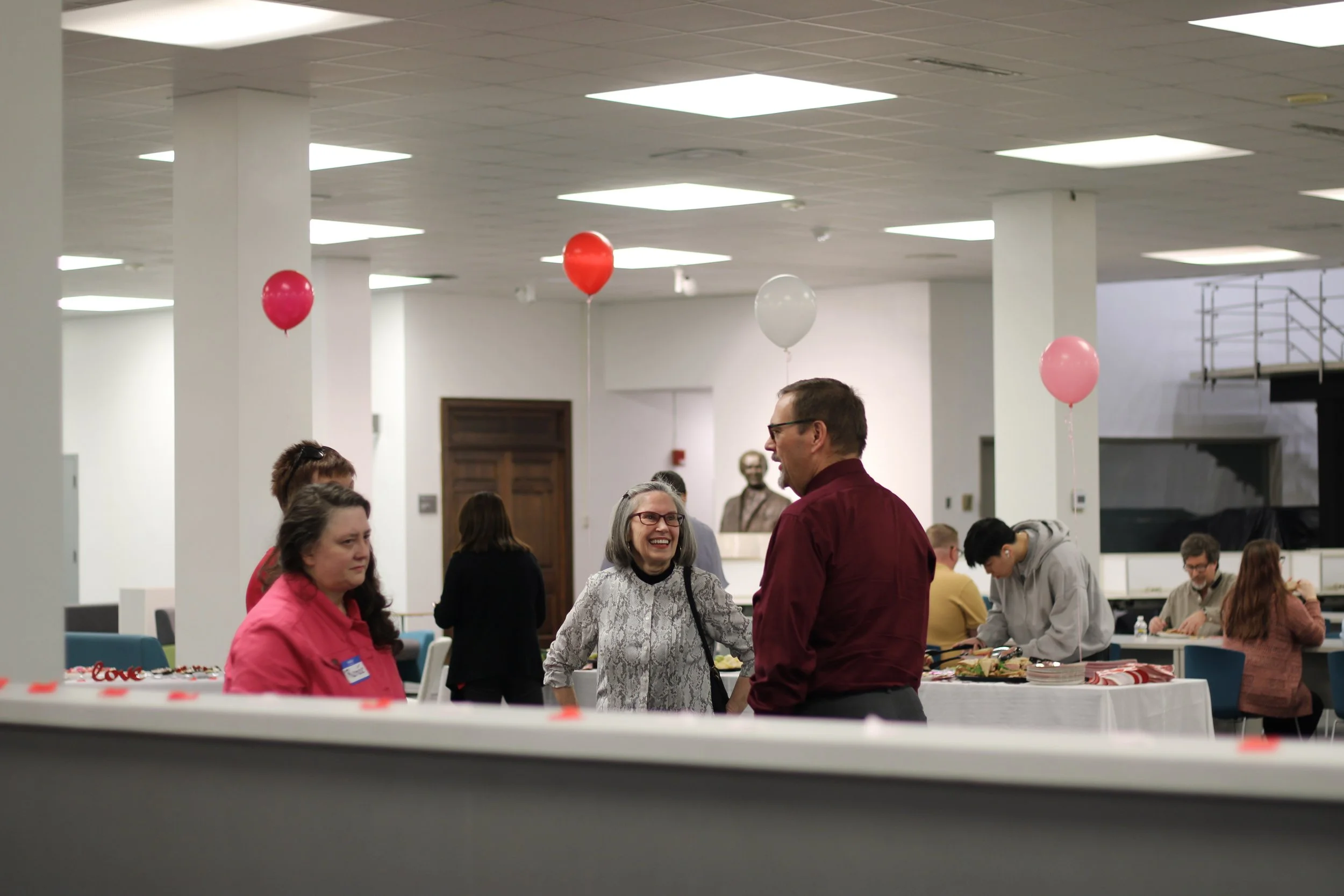  Lyn Dennison (left) and Brad Warren (right) speak with each other at the celebration recognizing the 60th anniversary of the library’s opening Feb. 15 on the Health Sciences Campus.  (photo by Rakiyah Lenon)  
