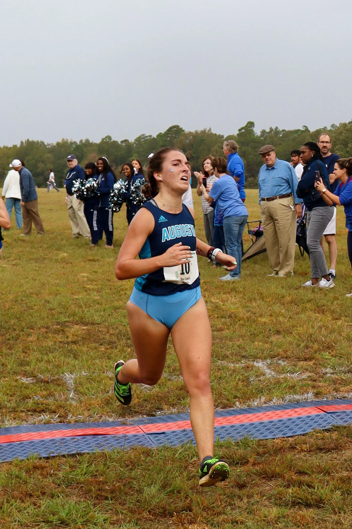  AU sophomore Riley Triplett crosses the finish line in fourth place with a time of 18 minutes, 54 seconds—her PR in the 5K race. She and Cassie Lagan helped the Jaguars to a third-place finish on a rainy Saturday morning at Redcliffe Plantation. At the top of the page, Lagan finished strong to take second place. (photos by Madison Keel) 