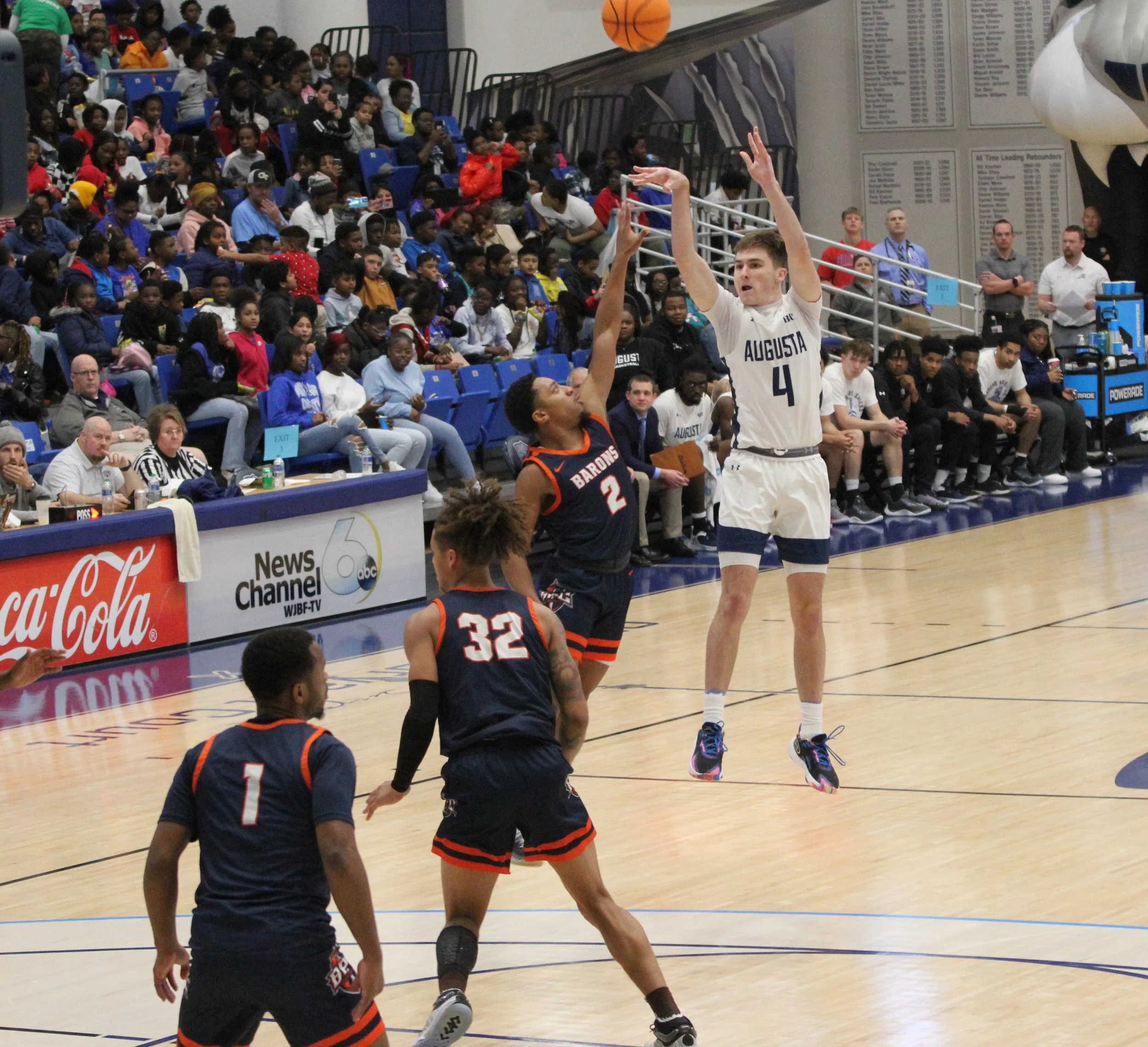  Carson Seemann (4) had six assists for the Jaguars. Here he shoots over the Barons’ Dre Burroughs (2) at Christenberry Fieldhouse on Richmond County Education Day. The Jaguars take 11 days off for exams before hosting Reinhardt University for Columbia Education Day on Dec. 18. (staff photo) 