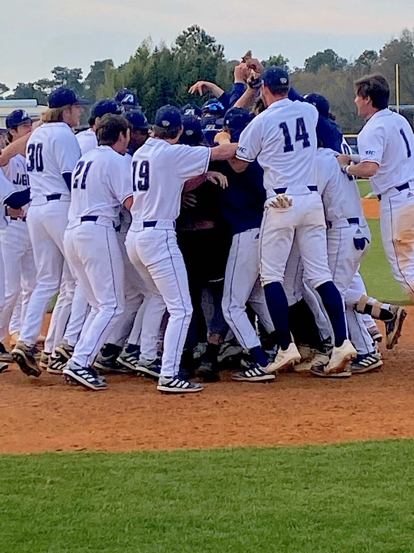  The Jaguars celebrate Jose Nogueras’s game-winning homer in the 9-8 win over Emmanuel. (photo by Chris Rickerson) At the top of the page, Nogueras swings for the fences. (photo by Carlos Rodriguez) 