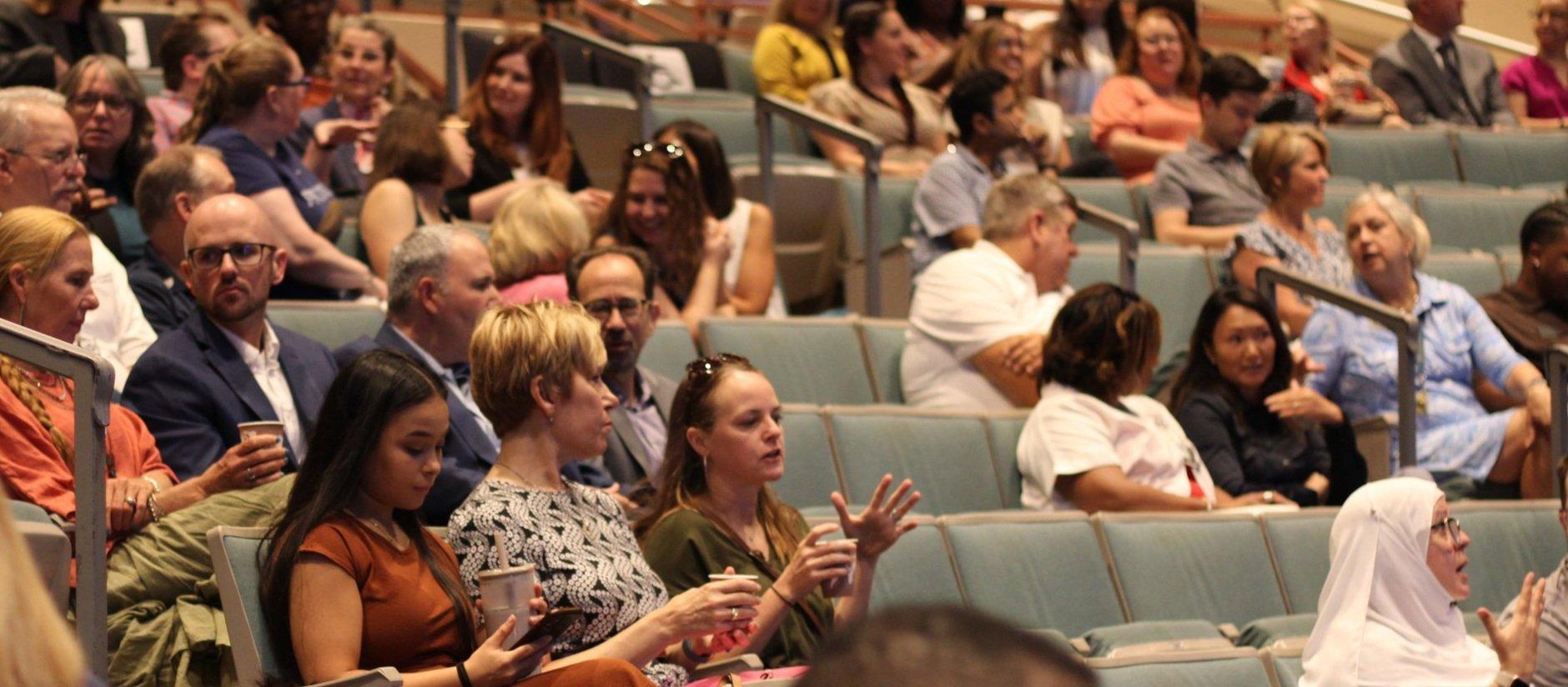  Faculty speak with each other at the Fall Faculty Kickoff in the Maxwell Theatre on Aug. 14.  (photo by Rakiyah Lenon)  