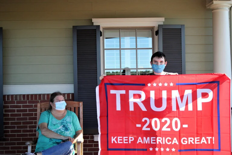   Jeffrey Fraizer displays a Trump supporting flag while his grandmother, Susan Fraizer, looks on. (photo by Haley Knight)  
