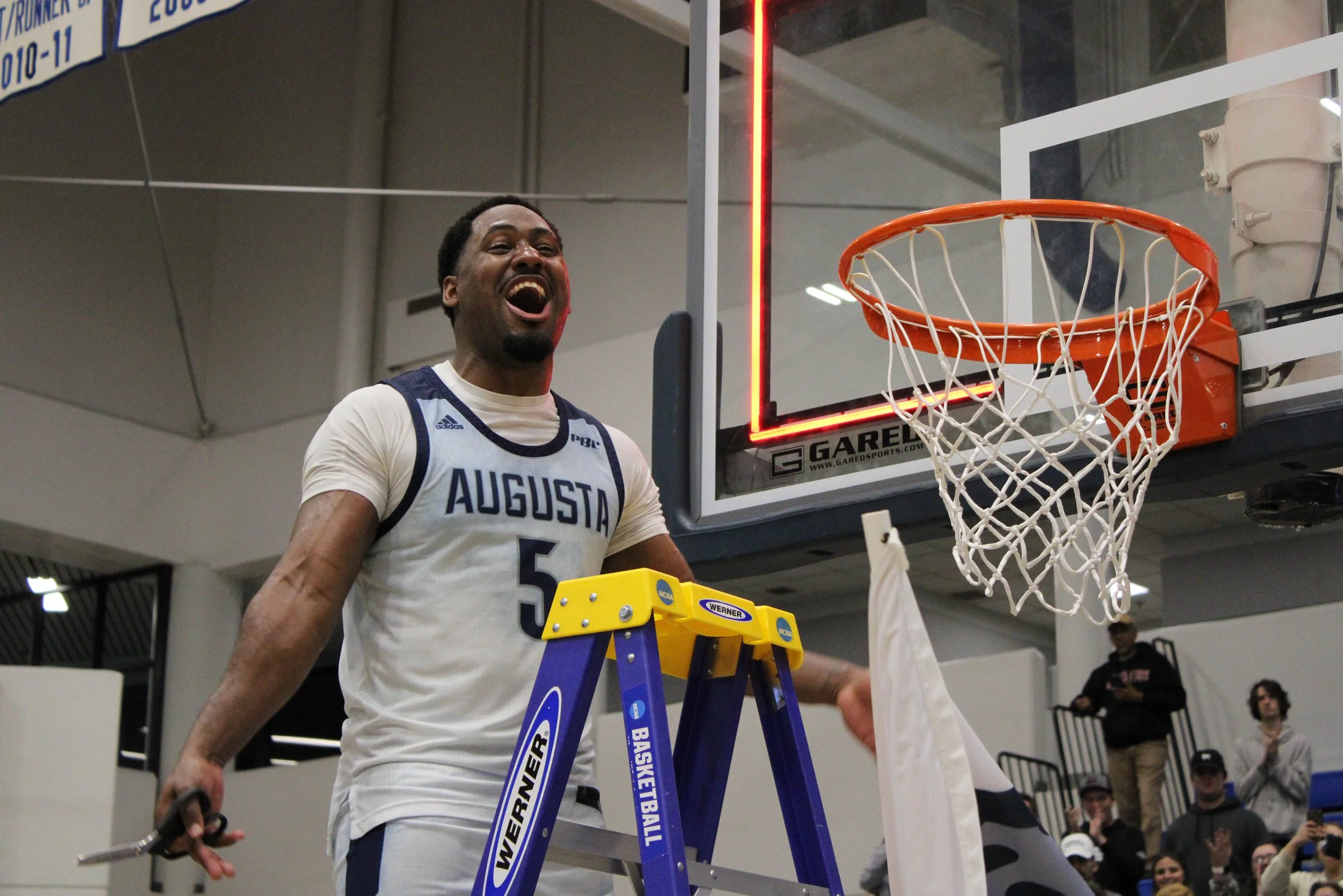  Jaguar guard Miguel Arnold prepares to cut down the regional championship net. (photo by Chris Rickerson) 