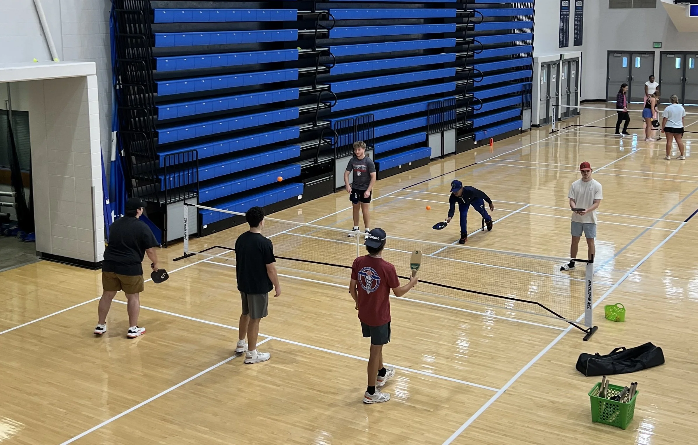  Students in a wellness class practice their pickleball techniques in Christenberry Fieldhouse. At the top of the page, Graham Hollrah (L) play pickleball with Department of Kinesiology instructor Harve Mobley. (photos by Ana Winters/the Bell Ringer) 