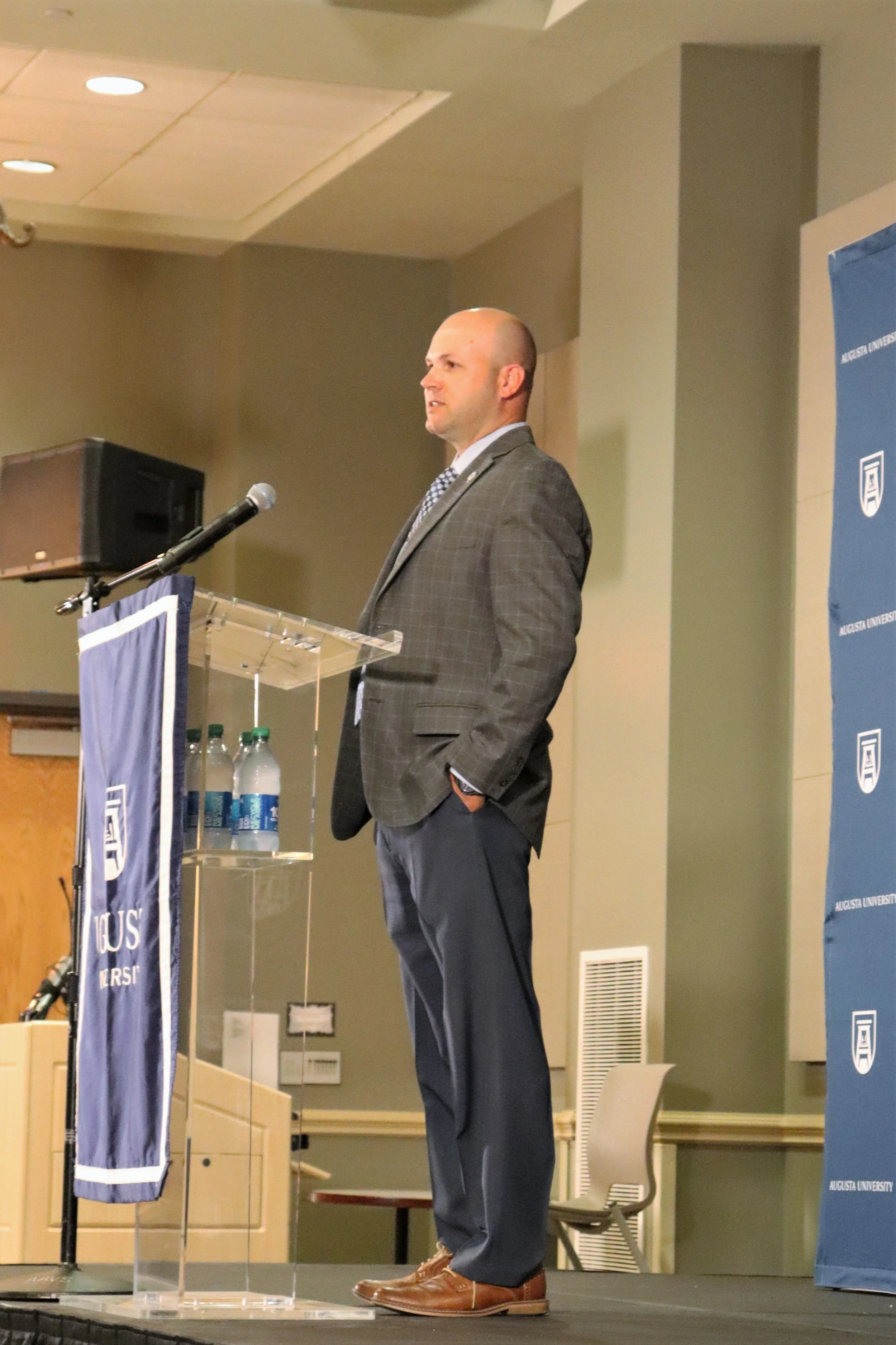  Ryan Erlacher addresses a packed JSAC Ballroom as he is introduced to the Augusta community. At the top of the page, Erlacher talks to journalists about his plans for AU’s athletic program. (photos by Madison Keel) 