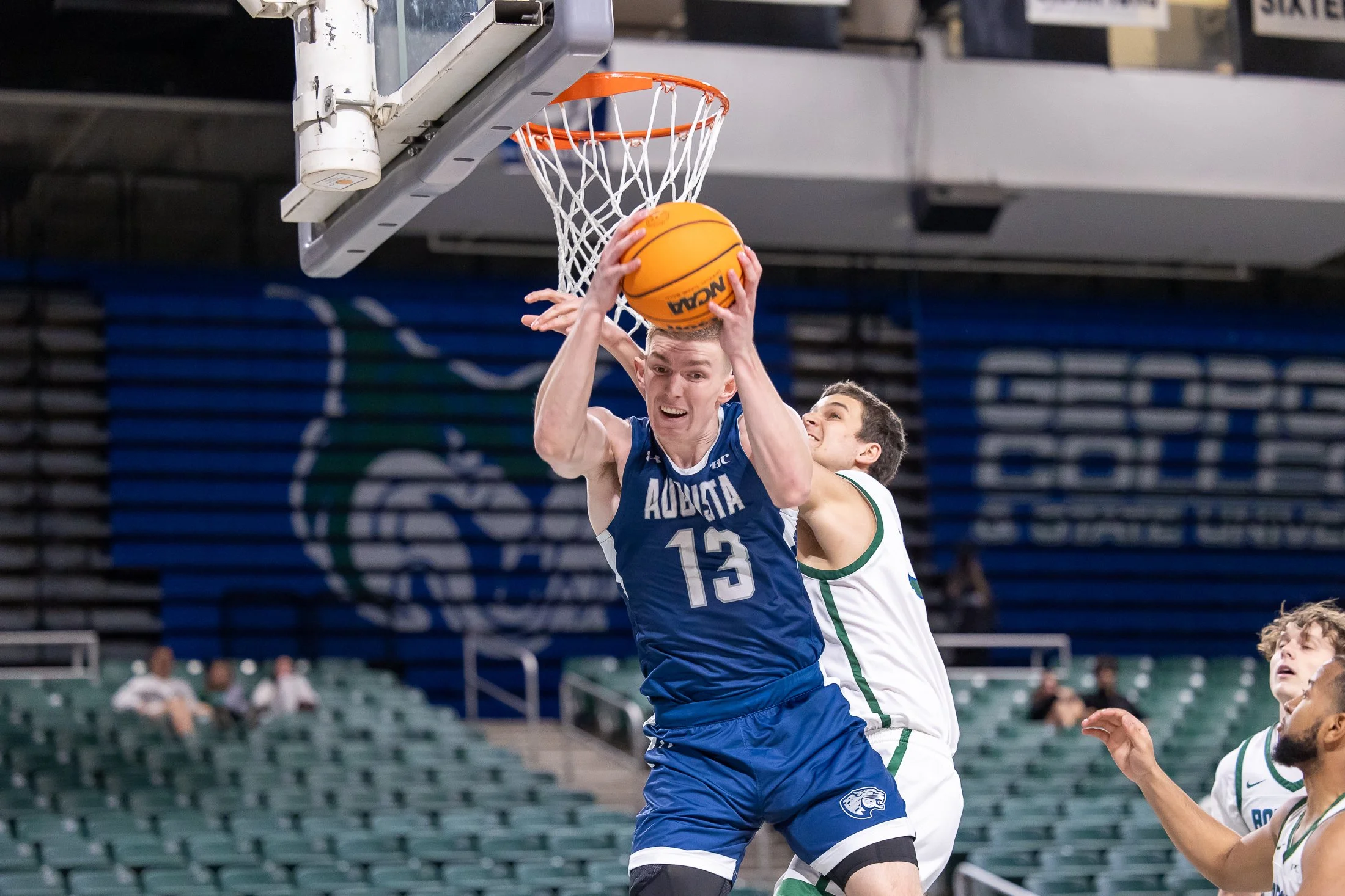  AU’s Oliver Lucas (13) grabs a rebound during the Jaguars’ 77-61 win over Georgia College and State University. At the top of the page, Augusta’s Ja’Queze Kirby scores two of his 22 in the Jags’ first road win of the PBC season. (photos by Paula Toole, AU Athletics) 