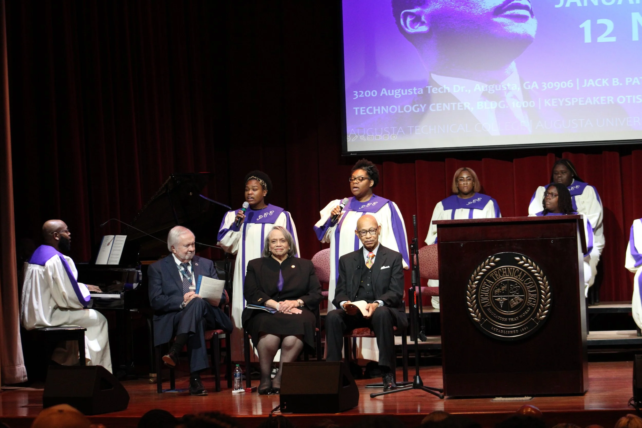  Seated from left to right, Augusta University President Brooks Keel. Paine College President Cheryl Evans Jones, keynote speaker Otis Johnson listen to songs presented by the colleges’ combined choirs.  (photo by Rakiyah Lenon)  